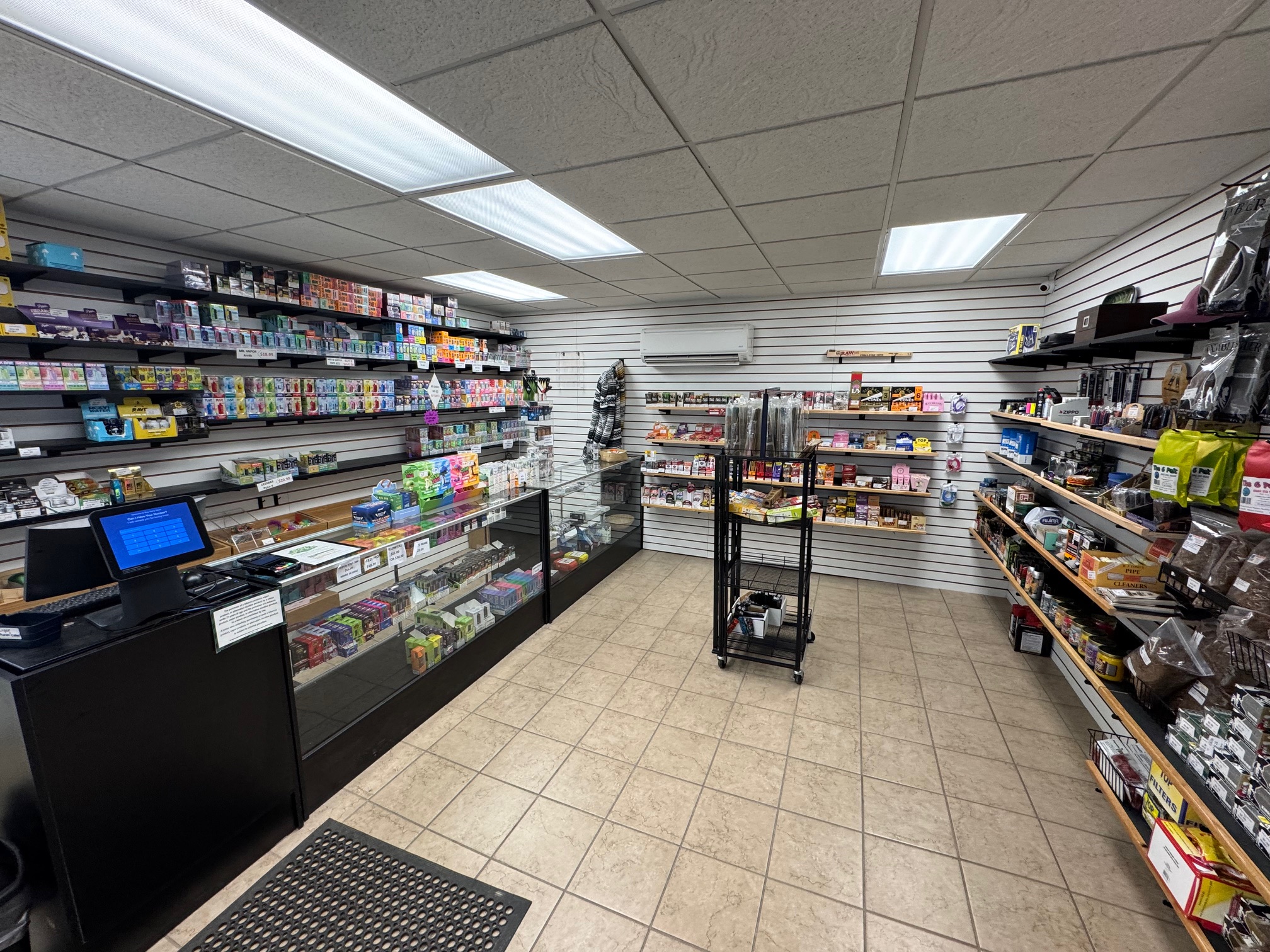 Inside the Bay Party Store smoke shop — display cases, glass, and wall of product